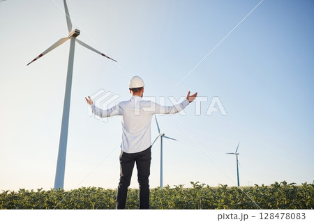 Conception of success and freedom. Service engineer is on the field with windmills 128478083