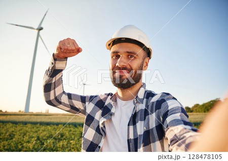 Making selfie. Service engineer is on the field with windmills 128478105