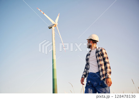 View from below. Service engineer is on the field with windmills View from below. Service engineer is on the field with windmills 128478130