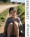 道端に座り込む少女 128478368