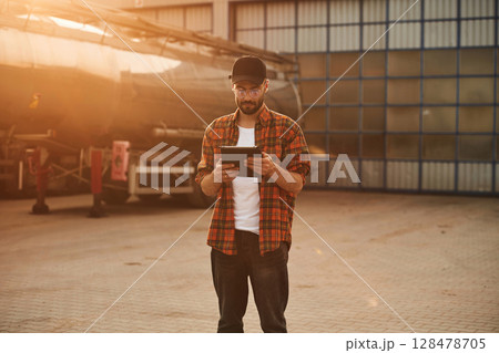 Digital tablet in hands. Young truck driver in casual clothes Digital tablet in hands. Young truck driver in casual clothes 128478705