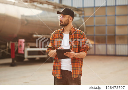 Digital tablet in hands. Young truck driver in casual clothes 128478707
