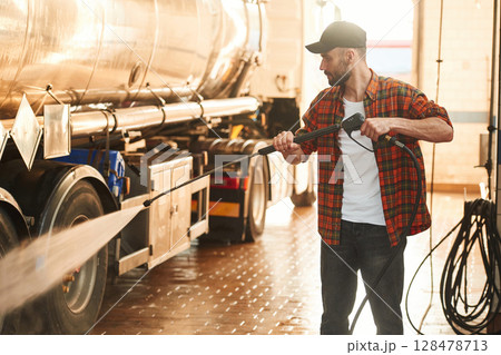 Washing the vehicle. Young truck driver in casual clothes 128478713