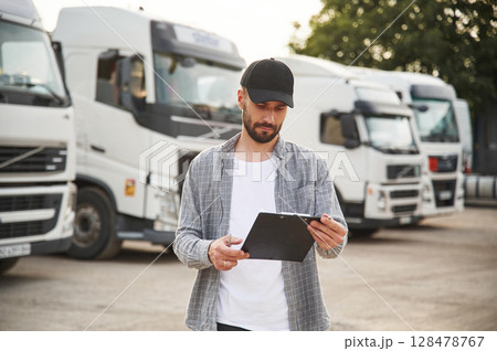 Manager is with notepad. Young truck driver in casual clothes 128478767
