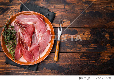 Tyrolean raw ham Speck, Italian sliced cured pork meat. wooden background. top view Tyrolean raw ham Speck, Italian sliced cured pork meat. wooden background. top view 128478786