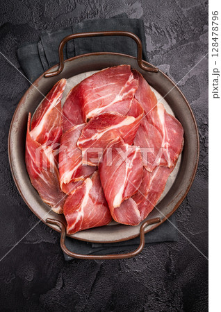 Thin slices of Speck, Jambon Italian cured meat. black background. top view 128478796