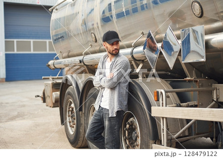 Leaning on the vehicle. Young truck driver in casual clothes 128479122