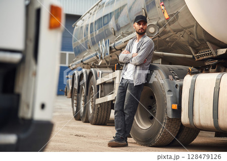 Leaning on the vehicle. Young truck driver in casual clothes 128479126