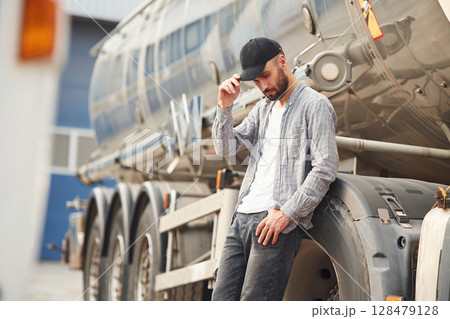 Touching the black cap. Young truck driver in casual clothes 128479128