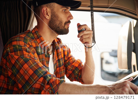 Communication by using radio. Young truck driver in casual clothes 128479171