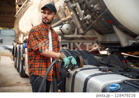 Young truck driver in casual clothes is refueling the vehicle 128479216