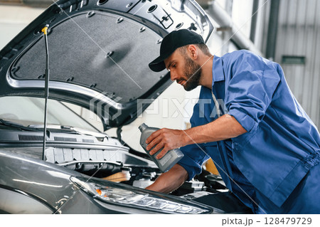 Process of changing the oil. Auto mechanic working in garage. Repair service Process of changing the oil. Auto mechanic working in garage. Repair service 128479729