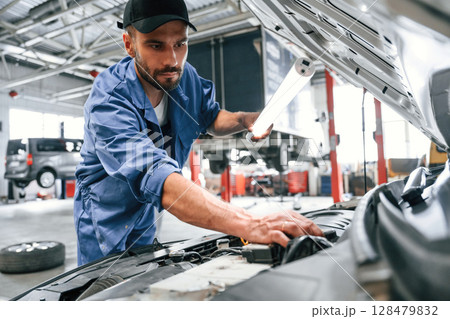Troubleshooting process. Auto mechanic working in garage. Repair service Troubleshooting process. Auto mechanic working in garage. Repair service 128479832