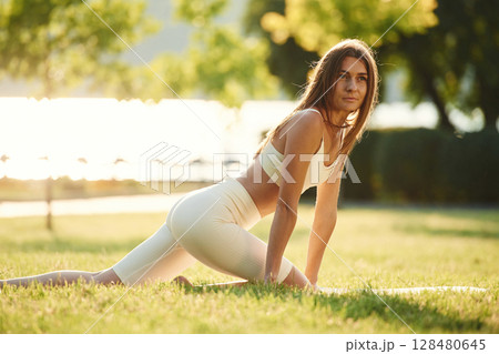 In the park at sunny daytime. Beautiful young woman in sportive clothes 128480645