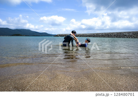 <素材>夏の海へ泳ぎにきて元気に遊ぶ兄弟 <素材>夏の海へ泳ぎにきて元気に遊ぶ兄弟 128480701