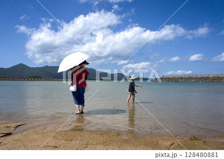 <素材>夏の海水浴場で遊ぶ親子(母子) <素材>夏の海水浴場で遊ぶ親子(母子) 128480881
