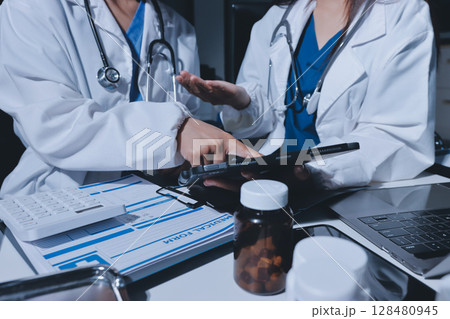 Male and female doctors are having a meeting in a hospital room. 128480945