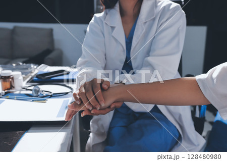 The doctor is checking and encouraging the patient. 128480980