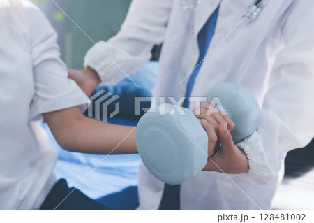 Unrecognizable uses blue hand weight during physical therapy session Unrecognizable uses blue hand weight during physical therapy session 128481002