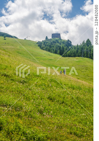 Hikers Ascending Sunny Green Hill Under Blue Sky with Clouds in Summer Landscape. High quality photo Hikers Ascending Sunny Green Hill Under Blue Sky with Clouds in Summer Landscape. High quality photo 128482080