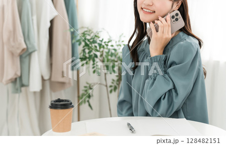 スマホで通話するおしゃれな若いアジア人女性 スマホで通話するおしゃれな若いアジア人女性 128482151