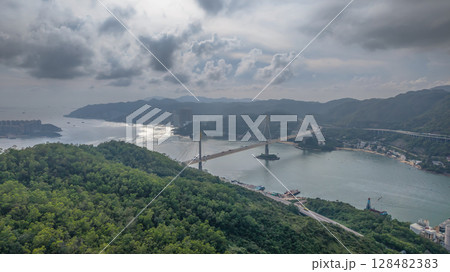 July 13 2025 Suspension Bridge Spanning Scenic Landscape of Hills and Waterway 128482383