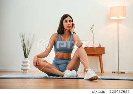 On yoga mat. Pretty woman in sportive clothes have fitness day indoors On yoga mat. Pretty woman in sportive clothes have fitness day indoors 128482622