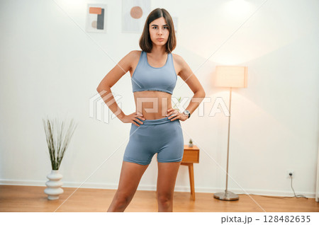 Front view. Pretty woman in sportive clothes have fitness day indoors 128482635