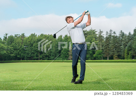 ゴルフ場でゴルフをするゴルファーの男性(笑顔・ティーショット) 128483369