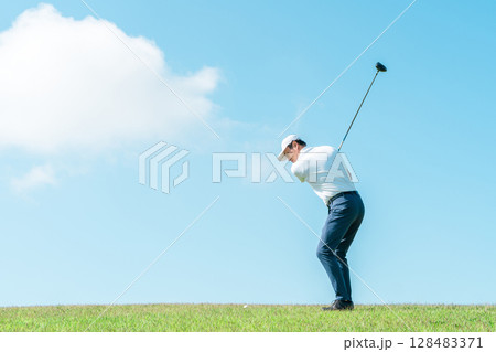 ゴルフ場でゴルフをするゴルファーの男性(笑顔・ティーショット・ゴルフコンペ) 128483371