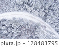 Winding road under winter weather conditions in a serene natural setting 128483795