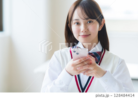 スマホを持つ女子高生 スマホを持つ女子高生 128484414