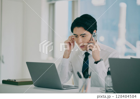 スーツ姿で働く男性 128484584