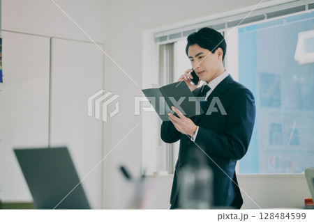 スーツ姿で働く男性 スーツ姿で働く男性 128484599