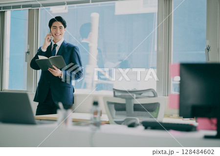 スーツ姿で働く男性 128484602