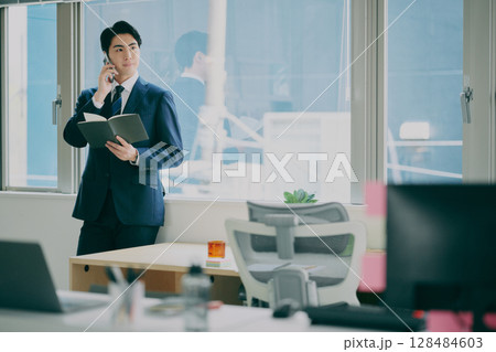 スーツ姿で働く男性 128484603