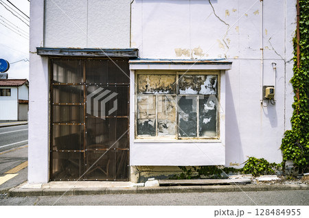 ひび割れた外壁と曇りガラスの窓|時の流れを感じる古い建物の外観 ひび割れた外壁と曇りガラスの窓|時の流れを感じる古い建物の外観 128484955