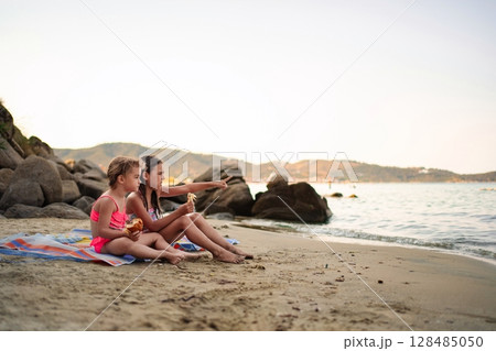 Joyful family moments shared on a sandy beach at sunset 128485050