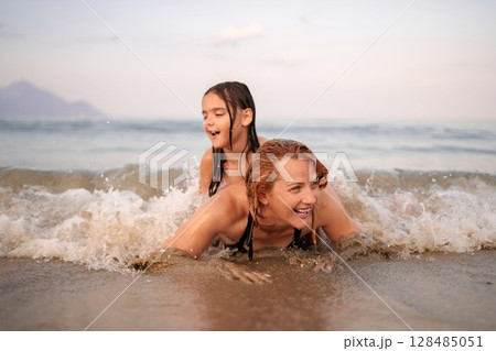 Joyful moments of family fun at the beach during sunset Joyful moments of family fun at the beach during sunset 128485051
