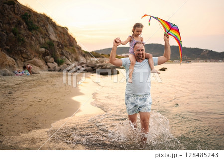 Joyful family beach day with a kite at sunset Joyful family beach day with a kite at sunset 128485243