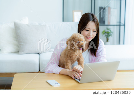 部屋でペットとくつろぐ若い女性 部屋でペットとくつろぐ若い女性 128486029