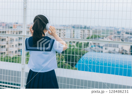 屋上で音楽を聴く女子高生 128486231