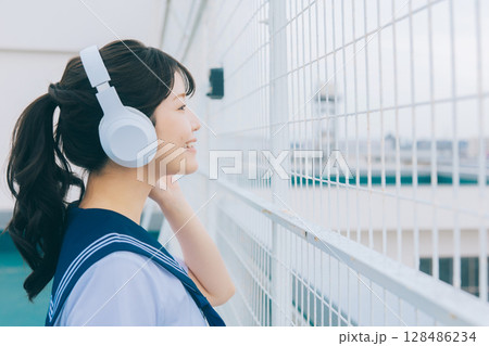 屋上で音楽を聴く女子高生 128486234