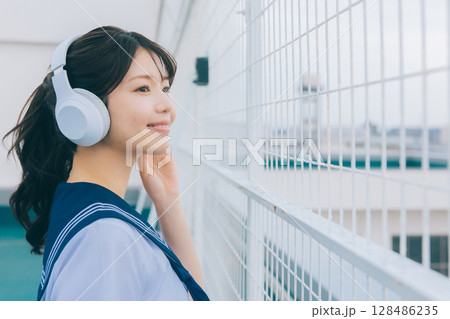 屋上で音楽を聴く女子高生 128486235