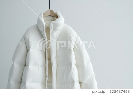 Blank template white down jacket with zipped, front view isolated on white background. Mockup winter jacket for design. Warm Puffer Hanging On Wall. Fashion clothes. Fall apparel. Modern youth style. 128487498