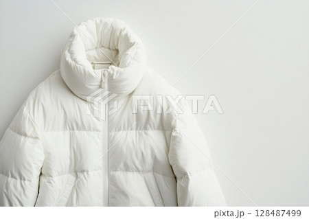 Blank template white down jacket with zipped, front view isolated on white background. Mockup winter jacket for design. Warm Puffer Hanging On Wall. Fashion clothes. Fall apparel. Modern youth style. 128487499