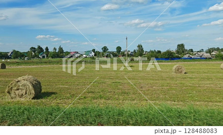 Driving through rural village in countryside on a sunny day. rural landscape from the window of a moving car 128488083