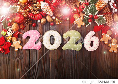 Colorful stitched digits 2026 of polkadot fabric with Christmas decorations flat lay background on wooden table Colorful stitched digits 2026 of polkadot fabric with Christmas decorations flat lay background on wooden table 128488116