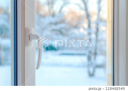 New plastic PVC window with white metal frame installed at modern house, view of blurred winter snow, blue sky. Advertising. Typical installation of insulated glazing windows with uPVC window frames. New plastic PVC window with white metal frame installed at modern house, view of blurred winter snow, blue sky. Advertising. Typical installation of insulated glazing windows with uPVC window frames. 128488540