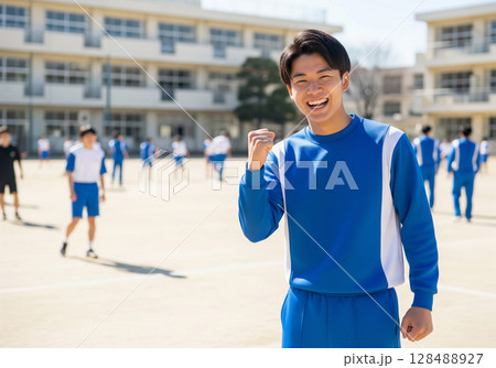 校庭で笑顔でガッツポーズする男子高校生 128488927